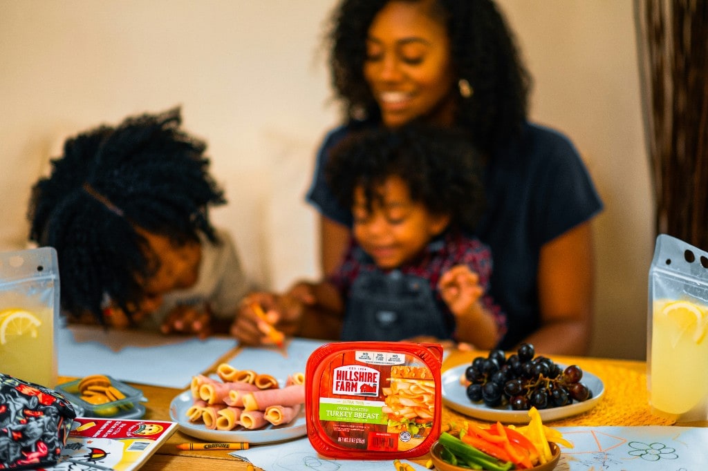 Mother and two children at the table with a packed lunch