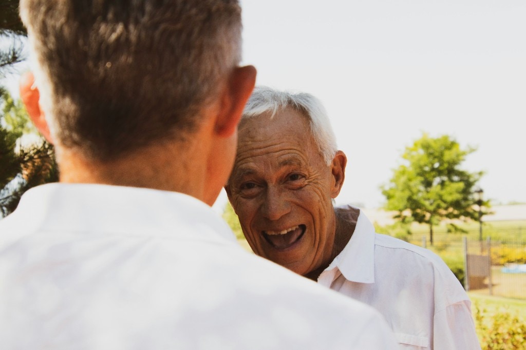 Two older friends laughing outdoors